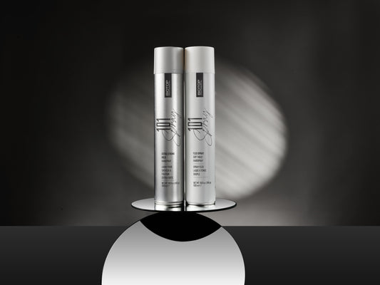 two silver Biotop 101 Create hairspray cans against a dark backdrop